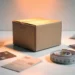 Cardboard shipping box on a white desk surrounded by product tags and a measuring tape, lit by a warm amber spotlight.