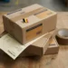 Stacked international shipping boxes on a warehouse desk with a VAT invoice and Belgium flag pin, warm amber and navy tones.