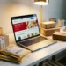 Laptop displaying an eBay storefront surrounded by branded product boxes and shipping parcels on a white desk with warm spotlight lighting.