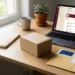 Organized desk with product catalog, shipping box, and business registration document beside a laptop displaying an online seller dashboard.