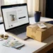 Euro munten en biljetten naast een laptop met productpagina, verzendoos en prijskaartje op wit bureau.