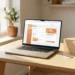 Laptop displaying a seller account setup page on a modern desk beside a small cardboard shipping box and credit card, warm natural light.
